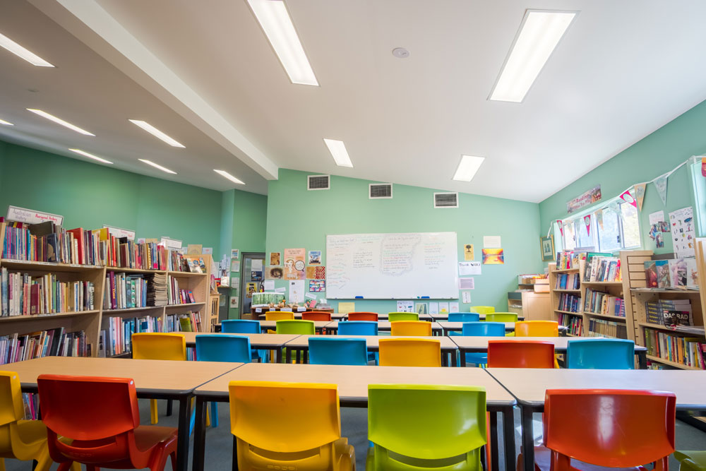 a bright classroom filled with assorted colorful chairs and tables